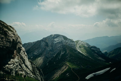 Scenic view of mountains against cloudy sky