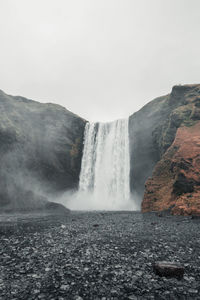 Scenic view of waterfall against sky