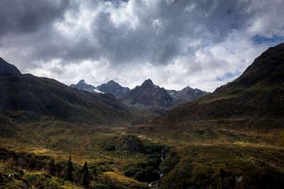 Scenic view of mountains against cloudy sky