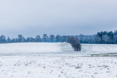 Snow on field against sky during winter