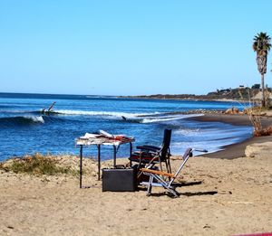 Empty chairs and table on calm beach