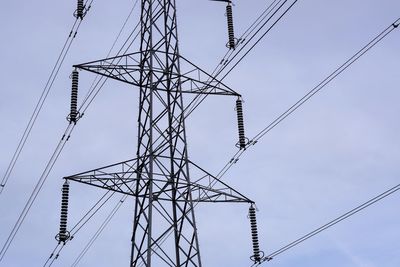 Low angle view of electricity pylon against sky