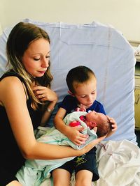 Woman with holding baby on son lap