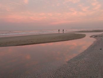Scenic view of beach against sky during sunset