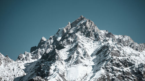 Scenic view of snowcapped mountains against clear blue sky