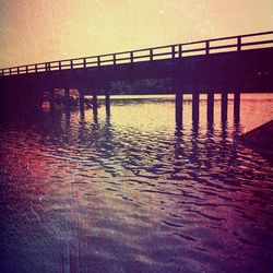 Pier in sea at sunset