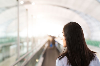 Rear view of woman standing against blurred background