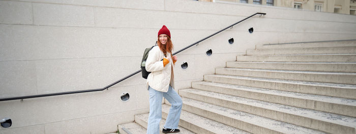 Low angle view of woman standing against wall