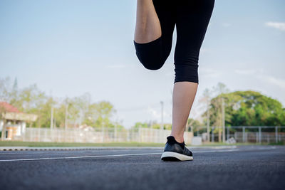 Low section of woman exercising at park