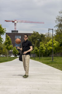 Close-up of mature man throwing basketball while standing outdoors