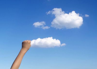 Low angle view of person against blue sky