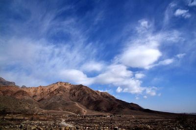 Scenic view of field and mountains against sky