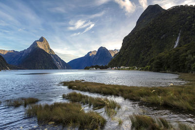 Scenic view of lake by mountains against sky