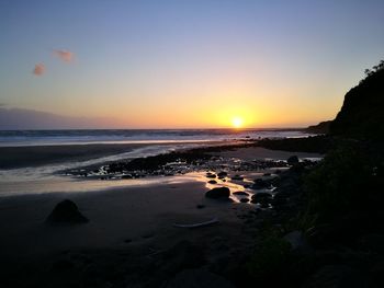 Scenic view of beach against sky during sunset