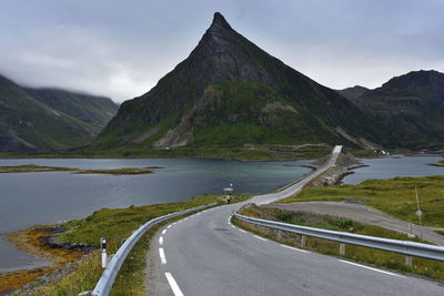 Scenic view of country road by mountains against sky