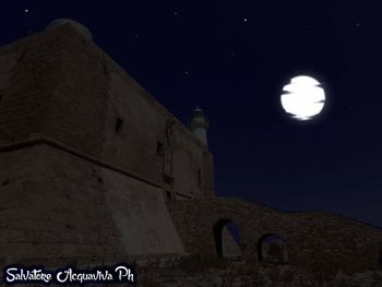 Low angle view of old building against sky at night