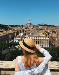Midsection of woman with building against sky