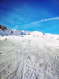 Scenic view of snow covered land against blue sky