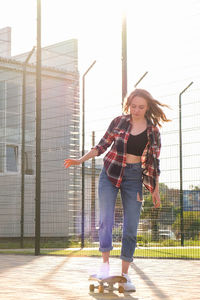 Woman riding a skateboard on street. skater girl on a longboard. cool female skateboarder at sunset. 