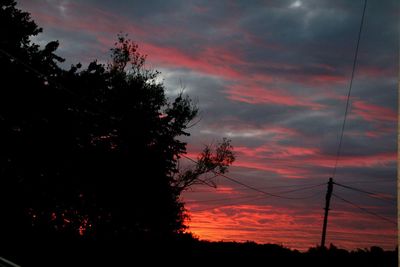 Silhouette of trees against cloudy sky