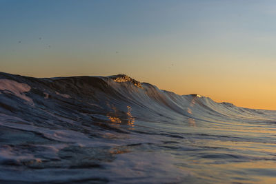 Scenic view of sea against clear sky during sunset