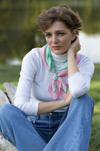 Portrait of young woman sitting on field