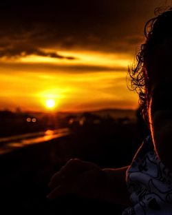 Portrait of silhouette woman against orange sky