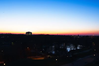 Illuminated cityscape against sky at sunset