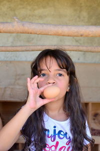 Portrait of girl holding egg 