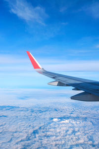 Airplane flying over clouds against blue sky