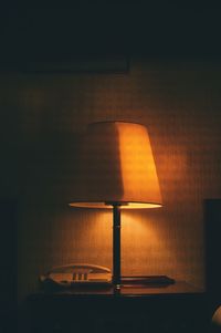 Illuminated lamp on table at home