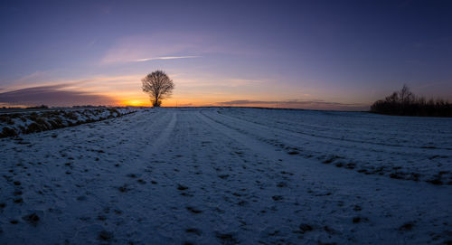 Scenic view of snow field against sky during sunset