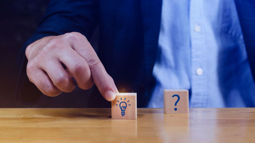 Midsection of man holding toy blocks on table