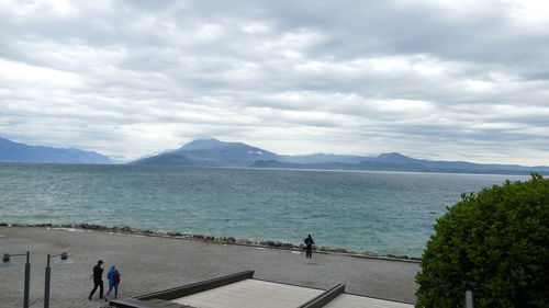 People standing by sea against sky