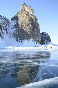 Scenic view of frozen sea by mountain against clear sky