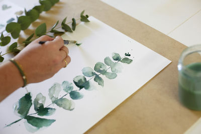 High angle view of a hand painting on table