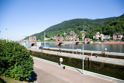 Scenic view of river by mountains against clear sky