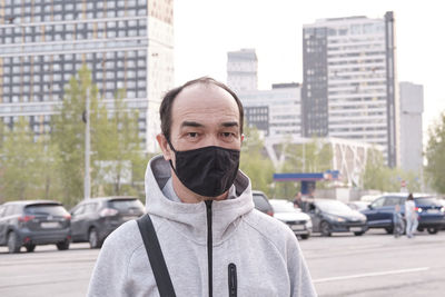 Portrait of man standing on street in city