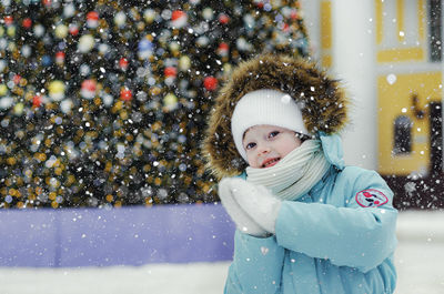 A cheerful girl on the background of a christmas tree.