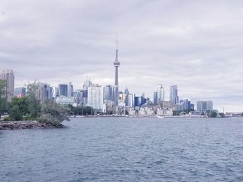 Buildings in city against cloudy sky