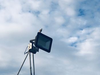 Low angle view of electric lamp against sky