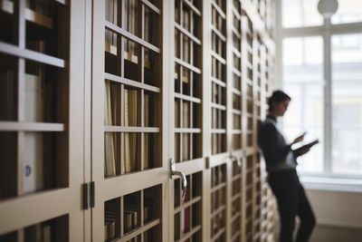 Female lawyer leaning on bookshelf in library