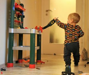 Rear view of baby boy playing while standing at home