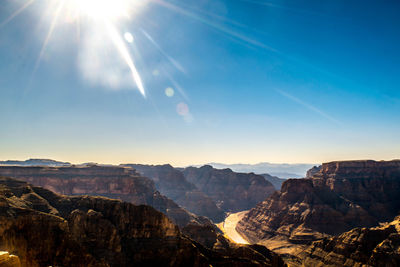 Scenic view of mountains against bright sun