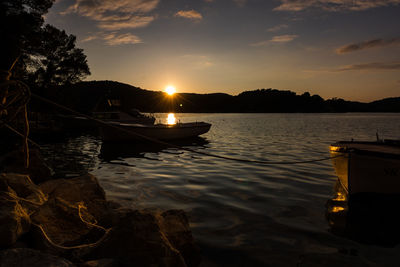 Boats sailing in sea against sky during sunset