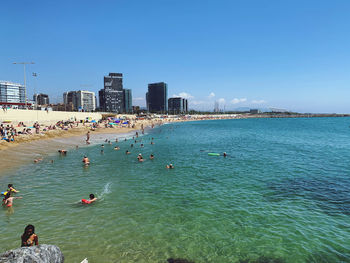 People at beach with city in background