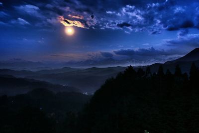 Scenic view of silhouette mountains against sky at night