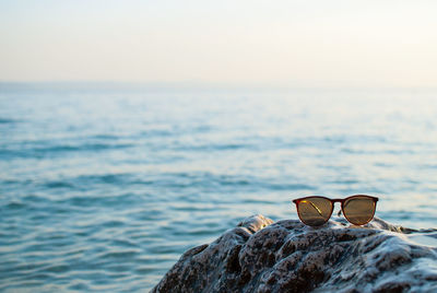 Close-up of sunglasses against sky