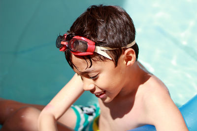 High angle view of shirtless boy swimming in pool