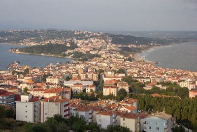 High angle view of townscape by sea against sky